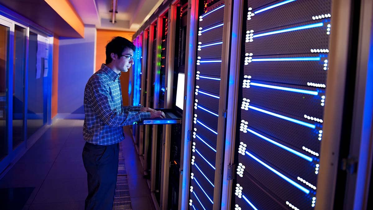 Man operating a computer in a server room