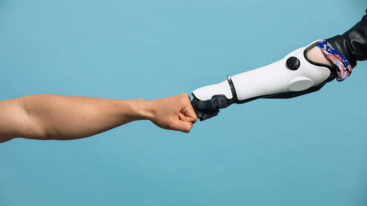 Image of a fist of human arm and a robot arm