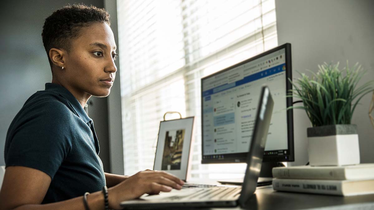 A woman at her desk working on her laptop